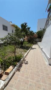 a brick walkway in front of a building with trees at Y.M.Apartment in Rhodes Town