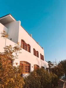 a white building with red windows and trees at Serenity Lodge in Sharm El Sheikh