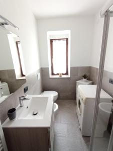 a white bathroom with a sink and a toilet at A casa di Gigi in Tione di Trento