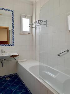 ein weißes Badezimmer mit Badewanne und Waschbecken in der Unterkunft Hotel Vila Verde in Castro Verde + 30 Fotos