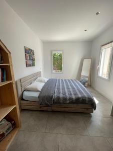 a bedroom with a bed and two windows at Villa Pierre et Mer, maison 6 personnes a deux pas des plages in Hyères