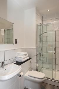 a bathroom with a toilet and a sink and a shower at The Olde Kings Arms in Hemel Hempstead