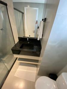 a bathroom with a sink and a mirror at Linda Cobertura vista mar no Residencial Affinity in Praia Grande