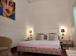 a bedroom with a bed and a painting on the wall at B&B Palazzo Sant'Alfano in Catania