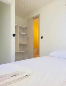 a white room with a bed and a mirror at Fortezzino in Rethymno