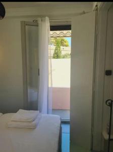 a bedroom with a bed and a window with towels at Fortezzino in Rethymno