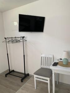 a room with a chair and a television on a wall at Apartman BANJA in Višegrad