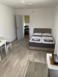 a bedroom with a bed and a desk with a laptop at Apartman BANJA in Višegrad