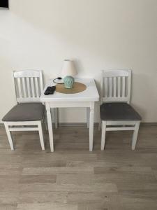 a white table with two chairs and a lamp on it at Apartman BANJA in Višegrad