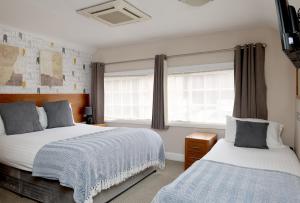 a bedroom with two beds and a window at The Olde Kings Arms in Hemel Hempstead