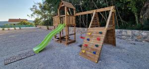 two wooden playground equipment with a slide and a ladder at House KID in Bribir