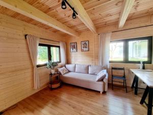 a living room with a white couch in a wooden room at Domek w Ińsku in Ińsko