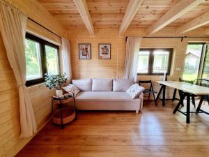 a living room with a white couch and a table at Domek w Ińsku in Ińsko