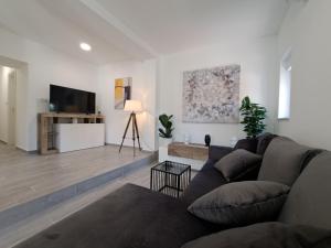 a living room with a couch and a flat screen tv at Holiday house SeaDream - 50 meters from the sea in Brodarica