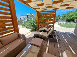 un patio avec un canapé et une chaise sur une terrasse dans l'établissement Holiday house SeaDream - 50 meters from the sea, à Brodarica