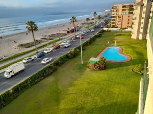 a street with cars parked on a road next to the beach at Department la Serena Beach in La Serena