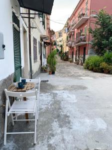 une table et une chaise blanche assise dans une rue dans l'établissement Casetta Lorica Porto Santo Stefano, à Porto Santo Stefano