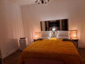 a bedroom with a large yellow bed with two pillows at VILLULA in Gien