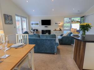 un salon avec un canapé bleu et une table dans l'établissement Hill Top Lodge, à Windermere