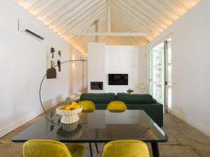 sala de estar con sofá verde y sillas amarillas en Agroturismo Suites Hacienda los Olivos, en Santa Brígida