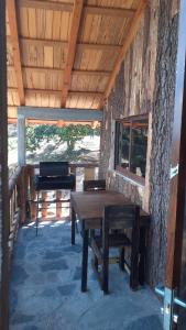 - une table en bois sur une terrasse couverte avec un banc dans l'établissement Cabaña cruz verde, à Pinal de Amoles