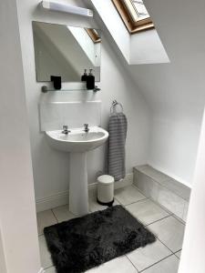 a white bathroom with a sink and a mirror at Spectacular Ocean Views in Tranquil and Private Location in Dooagh