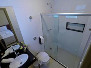a bathroom with a shower and a sink and a toilet at MIRAGE HOTEL in Porto Seguro