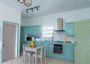 a kitchen with blue cabinets and a table with chairs at SOHI Villa in Gros Islet