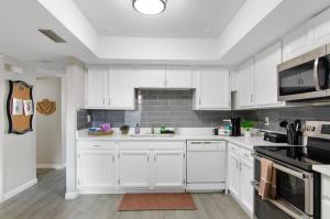 a white kitchen with white cabinets and appliances at Modern 2BR Getaway 15mn Phx. Intl Airport in Phoenix