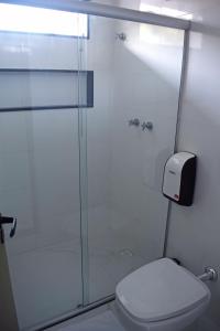 uma casa de banho com um WC e uma cabina de duche em vidro. em MIRAGE HOTEL em Porto Seguro