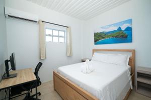 a bedroom with a bed and a desk and a computer at SOHI Villa in Gros Islet