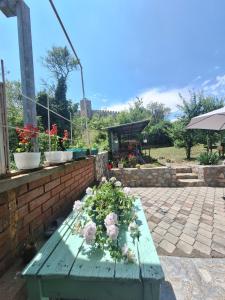 a green wooden bench with flowers on a patio at Villa Ella in Ohrid