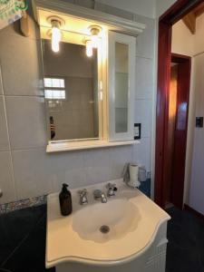 y baño con lavabo blanco y espejo. en Casa del Pinar - Excelente ubicación en centro de Plottier - Neuquén en Plottier