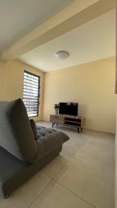 a living room with a couch and a flat screen tv at Auae hills lodge in Faaa