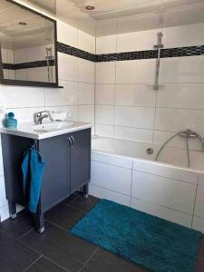 ein Badezimmer mit einem Waschbecken, einer Badewanne und einem Spiegel in der Unterkunft Amina’s Auberge nähe Saarbrücken in Alsting