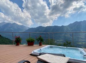 bañera de hidromasaje en una terraza con vistas a las montañas en Da Gigi, en Margno