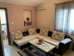 uma sala de estar com um sofá e uma mesa em Apartments Orfej em Sveti Stefan