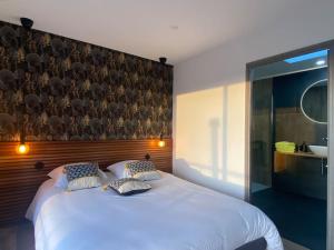 a bedroom with a large white bed with a wooden headboard at Nid douillet et moderne in Beauménil