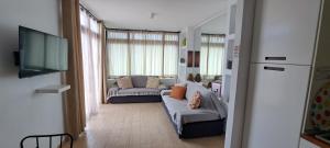 un soggiorno con divano e TV di El Gueco Holiday Apartment a Costa Teguise