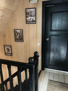 a hallway with a black door and pictures on the wall at Sodyba ramiam poilsiui in Kaltanėnai +23 photos