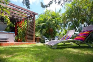 LES NUITS GALANTES MANDEVILLA MAISON PRIVÉE AVEC JACUZZI في سانت فرانسوا: ساحة فيها كرسيين جالسين على العشب
