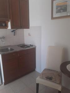 a kitchen with a sink and a stove and a chair at Gala in Punat