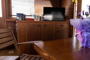 een woonkamer met een tafel en een televisie op een kast bij Barca sul fiume Magra LaSpezia in Luni