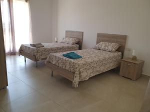 um quarto com 2 camas e uma mesa-de-cabeceira e um sidx sidx sidx em Menhir em Kirkop