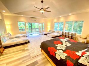 a large room with a bed and a couch at THE HONOMU HOUSE - Gorgeous, Spacious 4Bd2Ba Home near Waterfalls and Hilo, Sleeps 12! in Honomu