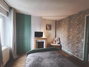 a bedroom with a bed and a wall with a fireplace at La Maison des Magnolias in Trouville-sur-Mer