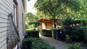 a small house with a tree and two trash cans at Drenthse-Groninger landschap in Haren