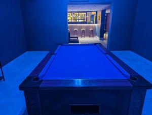 uma mesa de pingue-pongue num quarto com luzes azuis em Mayfair Hotel - Isle of Wight em Shanklin