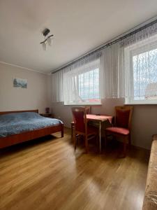 1 dormitorio con 1 cama, mesa y sillas en Willa Dominik 2 en Jastarnia