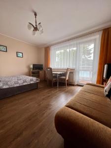 a bedroom with two beds and a table and a window at Willa Dominik 2 in Jastarnia